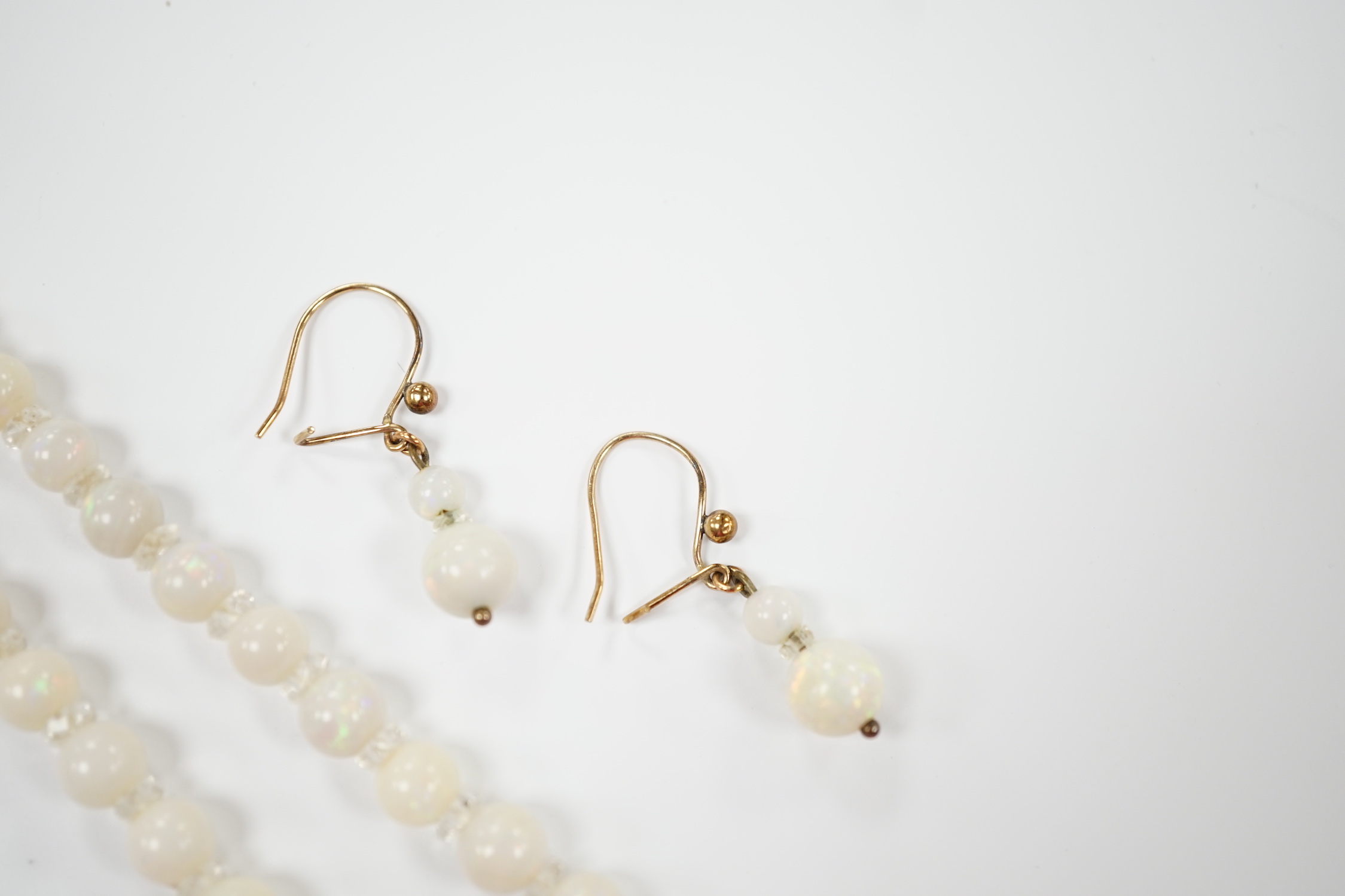 A single strand graduated white opal bead necklace, with 9ct clasp, 50cm and a pair of similar drop earrings.